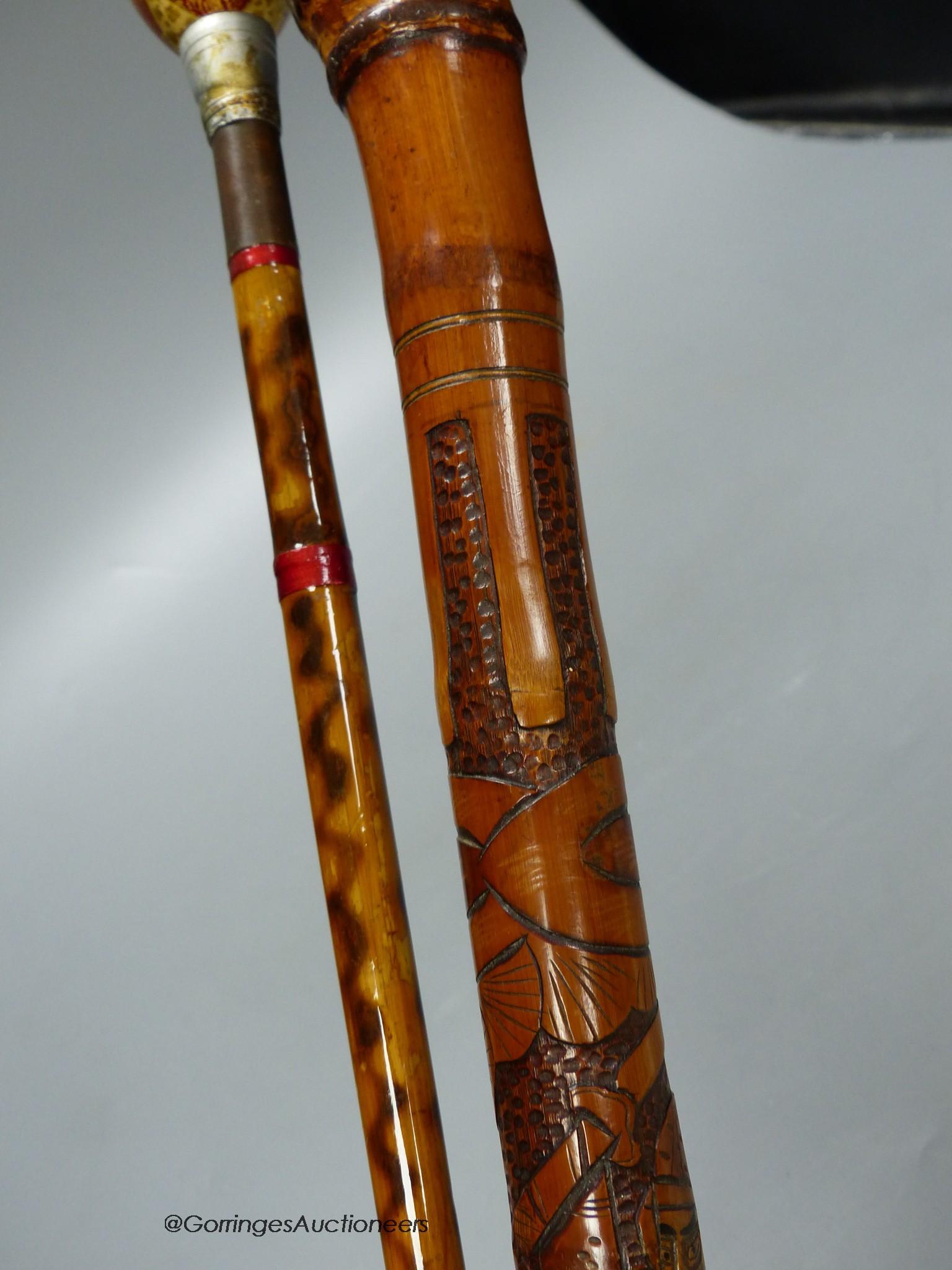 A Japanese carved bamboo walking stick and a Persian polychrome painted walking cane, tallest 97cm